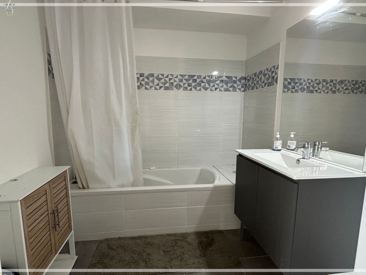 Salle de bains avec baignoire et meuble vasque