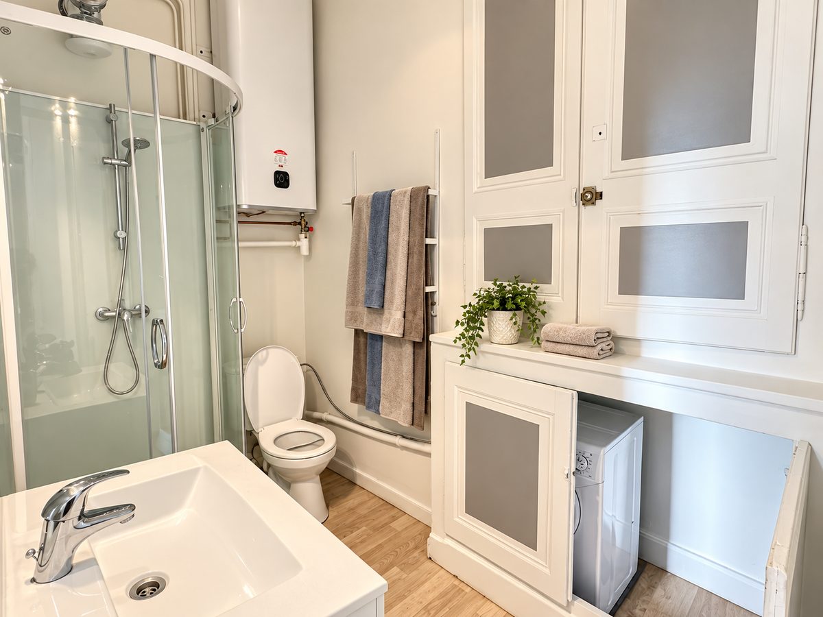 Salle d’eau avec douche, vasque et rangements